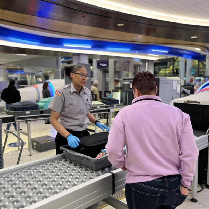 VMD security employee interacts with passenger at security line